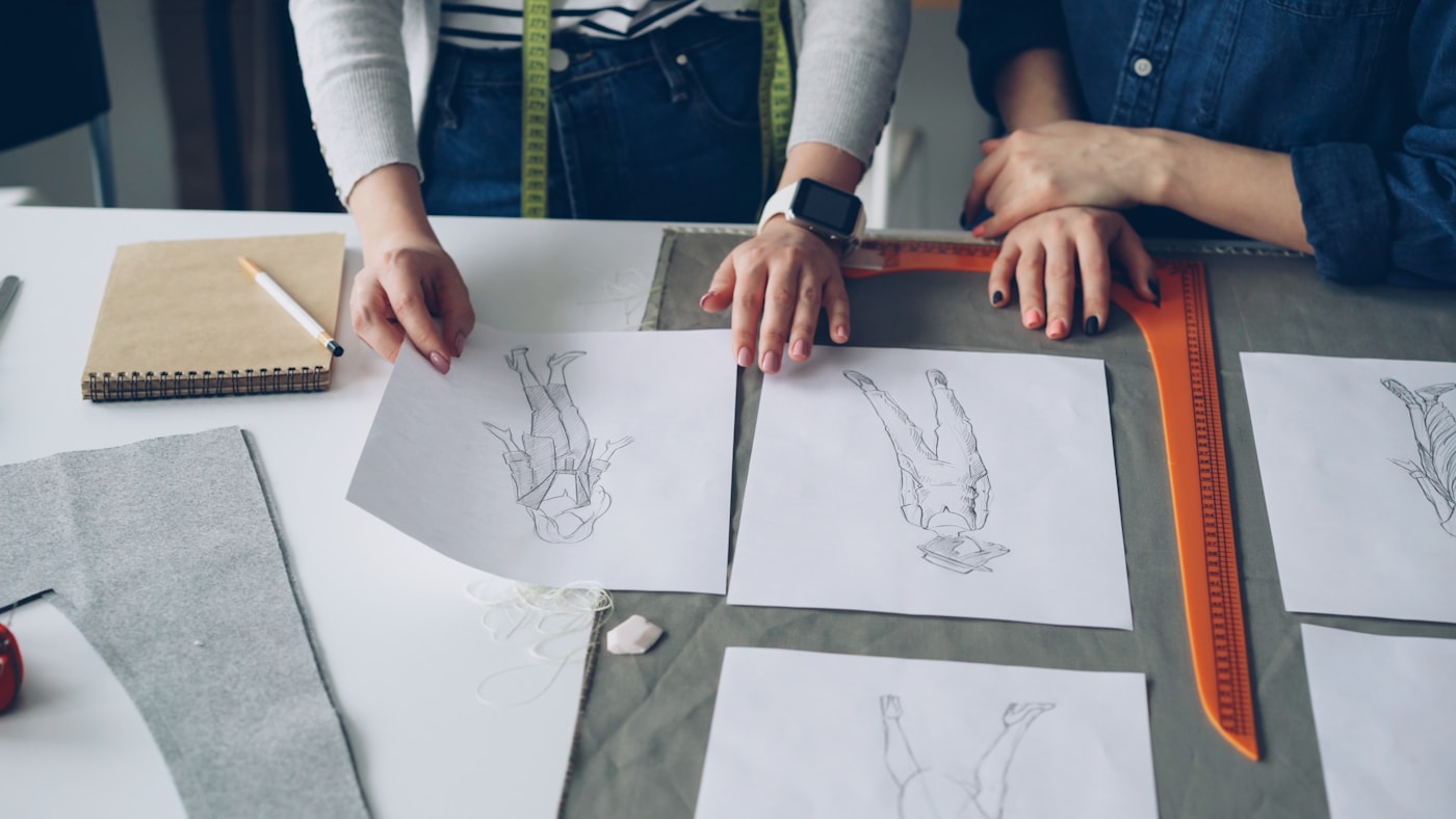 Fashion designers reviewing garment sketches for a product line extension